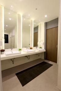 a bathroom with two sinks and a large mirror at The Printing House Poshtel in Bangkok