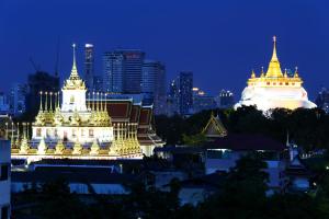 a lit up building with a city in the background at The Printing House Poshtel in Bangkok