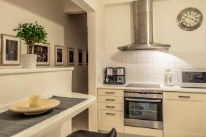 a kitchen with a table and a clock on the wall at Elegant Supercentral Apartment in Thessaloniki