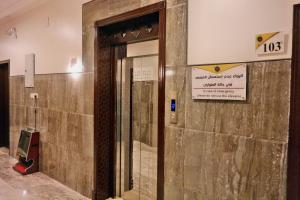 a door in a building with a sign on it at فضة تالا للشقق المخدومة 1 in Buraydah