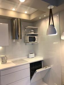 a white kitchen with a microwave and a stove at Orlando Ocean Star in Adeje