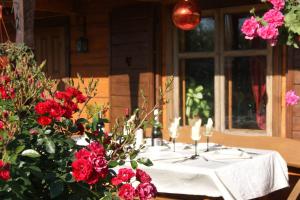 un tavolo con fiori rossi e candele sopra di Traku Horizontai a Trakai