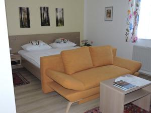 ein Wohnzimmer mit einem Sofa und einem Bett in der Unterkunft Gästehaus Haagen in Bad Waltersdorf