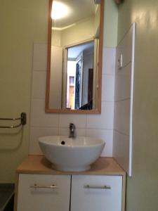 ein Badezimmer mit einem weißen Waschbecken und einem Spiegel in der Unterkunft Studio Porteille d'Ax in Ax-les-Thermes