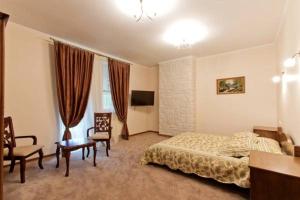 Park-Hotel Butenko Stable في Protsev: غرفة نوم بسرير وطاولة وكراسي