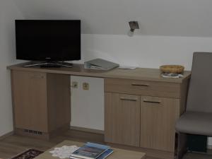 einen Schreibtisch mit einem TV darüber in der Unterkunft Gästehaus Haagen in Bad Waltersdorf