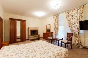 1 dormitorio con cama, sillas y chimenea en Park-Hotel Butenko Stable en Protsev