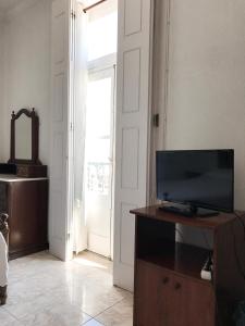 sala de estar con TV en un armario de madera en Alojamento Baixa Mar, en Vila Real de Santo António