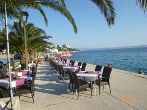 a row of tables and chairs next to the ocean at Haus Sonja in Podgora