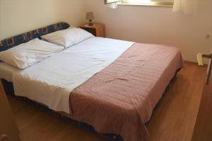 a large bed in a bedroom with a wooden floor at Apartment Rina in Vantačići