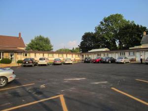 a parking lot with cars parked in front of a building at Canadiana Motel in Hanover
