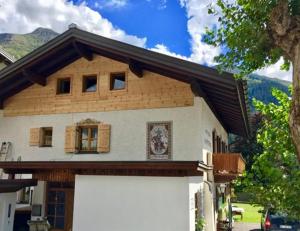 ein Haus mit einer weißen Garage davor in der Unterkunft Landhaus Sonnenberg in Sankt Anton am Arlberg