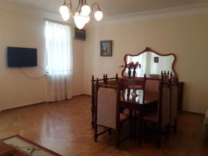 uma sala de jantar com um espelho e uma mesa com cadeiras em Apartment on Rustaveli 41 em Batumi