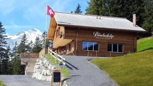 un edificio con una bandera a un lado. en Bischofalp, en Elm