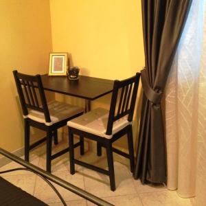 uma mesa de jantar com 2 cadeiras e uma mesa com uma fotografia em Cherry House Bed&Breakfast em Campobasso