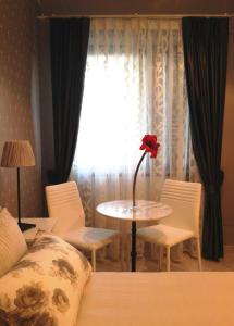 um quarto com uma mesa com uma flor vermelha em Cherry House Bed&Breakfast em Campobasso