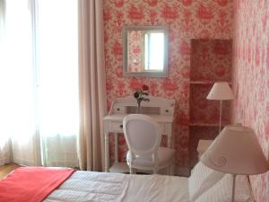 a bedroom with a bed and a desk and a mirror at Hotel Villa Rivoli in Nice +37 photos