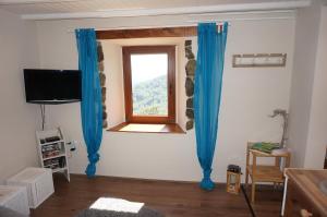 een woonkamer met blauwe gordijnen en een raam bij Valley View Apartment in Kambreško