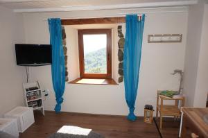 a living room with blue curtains and a window at Valley View Apartment in Kambreško