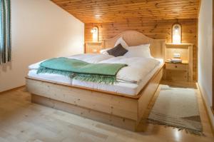 a bedroom with a large bed with a wooden ceiling at Gasperhof in Dellach