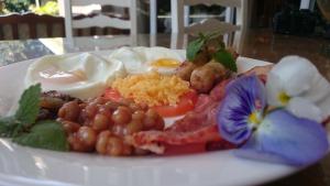 a plate of food with eggs and vegetables on a table at Convent Hill Lodge in Ladysmith