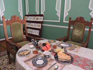 a table with plates of food on it at Meros B&B in Khiva