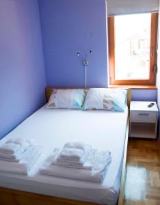 ein Bett mit Handtüchern in einem Zimmer mit Fenster in der Unterkunft Apartman Lena in Vrnjačka Banja