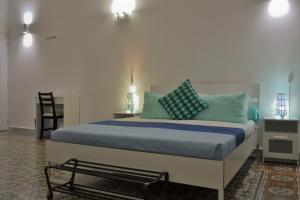 Dietro al Massimo في باليرمو: غرفة نوم مع سرير ووسائد زرقاء وأخضر
