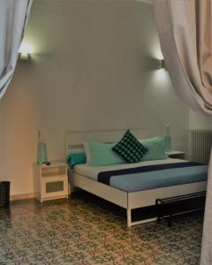 1 dormitorio con 1 cama con almohadas azules y verdes en Dietro al Massimo en Palermo