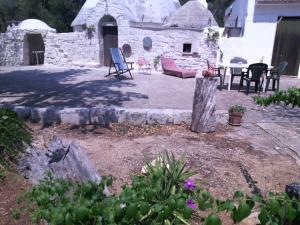 un patio trasero con una casa de piedra con mesa y sillas en Casa Zappa D'argento in Salento, en Francavilla Fontana
