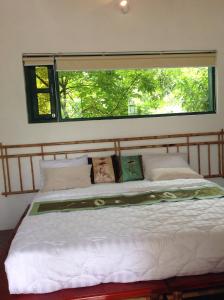 a bedroom with a large bed with a large window at Tam Coc Eco House in Ninh Binh