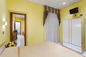 - une chambre avec un lit et une télévision murale dans l'établissement Hotel Oriente, à Rome