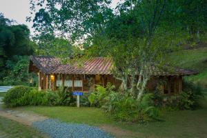 una pequeña casa con un cartel delante en Pousada da Oma, en Cunha