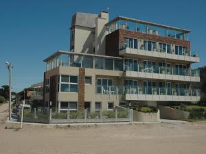 a building on the beach next to the sand at La Medusa Valeria in Valeria del Mar