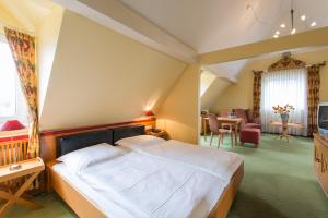 a bedroom with a large bed and a living room at Hotel Eisbach in Ransbach-Baumbach