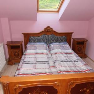 a bed in a room with two end tables at Pálya Vendégház in Pusztaszer