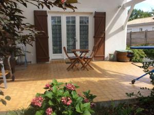 a patio with a wooden table and chairs on it at La Bulle in Audenge