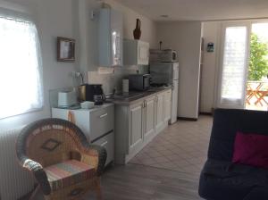 a kitchen with a couch and a chair in a room at La Bulle in Audenge