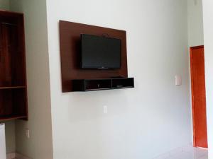 a flat screen tv on a wall in a room at Pousada Arraial Das Cores in Pirenópolis