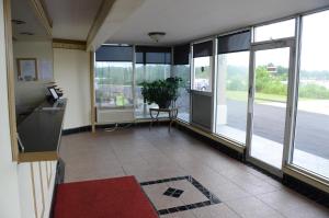 an empty room with glass doors and a floor at Big Spring Inn Madisonville in Madisonville
