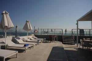 a group of lounge chairs and umbrellas on a roof at Astron Suites & Apartments in Kos
