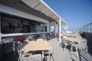 un patio con tavoli, sedie e un bar di Astron Suites & Apartments a Città di Kos