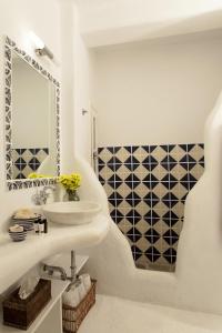 a white bathroom with a sink and a mirror at Beachfront Mykonos Guest House in Ornos