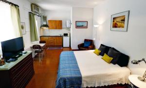 um quarto de hotel com uma cama e uma cozinha em Alojamentos Oasis em Mértola