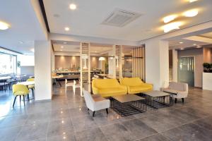 a lobby with yellow furniture and a dining room at Astron Suites & Apartments in Kos