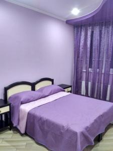 um quarto com uma cama roxa e cortinas roxas em Mini-hotel em Uman