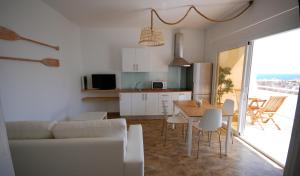 a kitchen and living room with a table and chairs at El Aceitun Beach Holiday Homes in Gran Tarajal