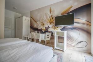 ein Schlafzimmer mit einem Bett und einem TV an der Wand in der Unterkunft Hotel Fürstenberger Hof in Xanten