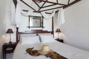 1 dormitorio con 1 cama con sombrero en Beachfront Mykonos Guest House en Ornos