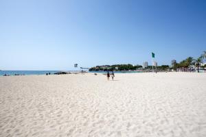 two people standing on a white sandy beach at Magalluf Playa Apartments - Adults Only in Magaluf